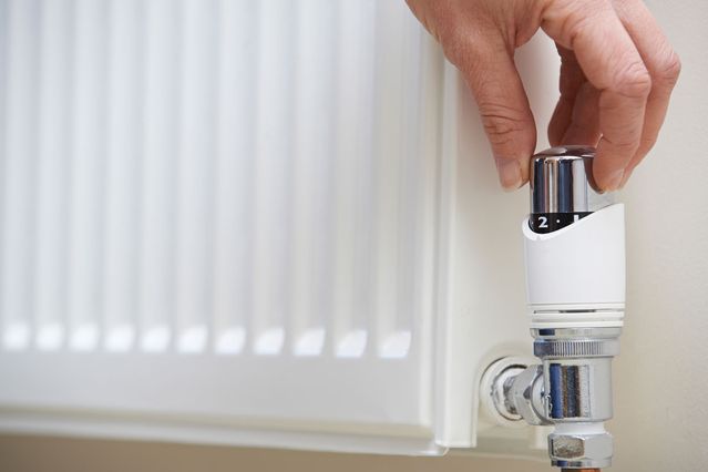 A plumber checking a radiator